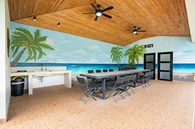 a dining room with a table and palm trees mural at Modern Home with Lush Mountain Views and Spectacular Shaded Terrace in Private Gated Community in Potrero