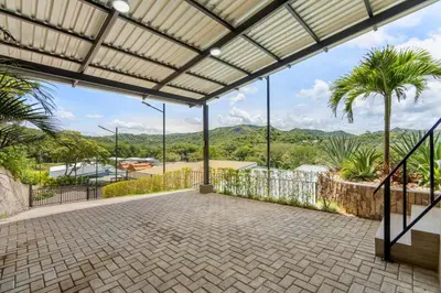 an empty patio with palm trees and mountains in the background at Modern Home with Lush Mountain Views and Spectacular Shaded Terrace in Private Gated Community in Potrero
