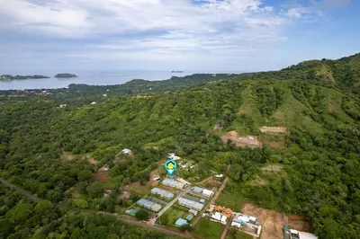 an aerial view of a green hill with a building at Modern Home with Lush Mountain Views and Spectacular Shaded Terrace in Private Gated Community in Potrero