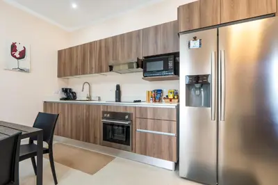 a kitchen with a stainless steel refrigerator and a table at Modern Home with Lush Mountain Views and Spectacular Shaded Terrace in Private Gated Community in Potrero