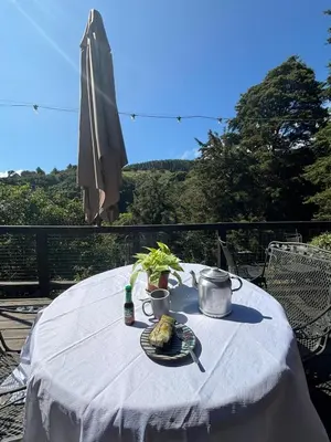 a table with a plate of food and an umbrella at Cabaña de Montaña 9per Aire Fresco & Naturaleza in Trojas