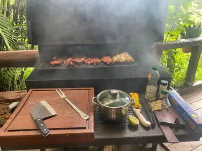 a grill with some meat cooking on a table at Cabaña de Montaña 9per Aire Fresco & Naturaleza in Trojas