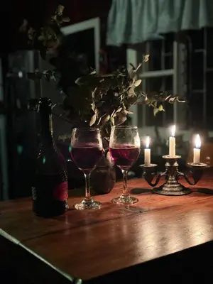two glasses of wine and a bottle on a table at Cabaña de Montaña 9per Aire Fresco & Naturaleza in Trojas