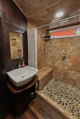 a bathroom with a sink and a shower at Cabaña de Montaña 9per Aire Fresco & Naturaleza in Trojas