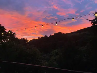 a string of lights in front of a sunset at Cabaña de Montaña 9per Aire Fresco & Naturaleza in Trojas