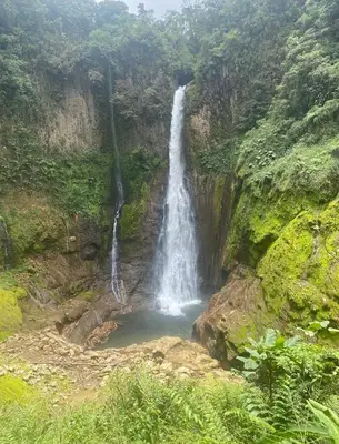 a waterfall on the side of a mountain at Cabaña de Montaña 9per Aire Fresco & Naturaleza in Trojas