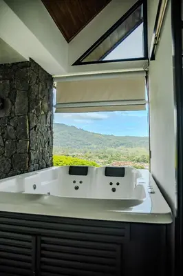 a bath tub in a bathroom with a window at Villa Bosque CR in Turrialba
