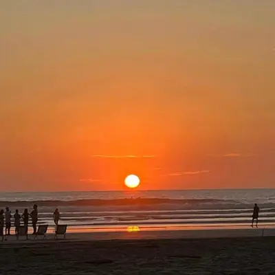 people standing on the beach watching the sunset at Casa Nosara a 10 minutos de las playas en auto in Nosara