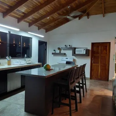 a kitchen with a large island with bar stools at Casa Nosara a 10 minutos de las playas en auto in Nosara
