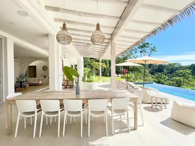 an outdoor patio with a wooden table and chairs at Casa Niri in Nicoya
