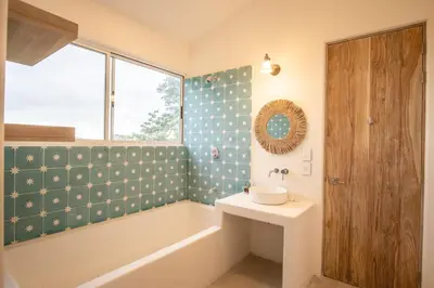 a bathroom with a sink and a tub and a window at Casa Niri in Nicoya