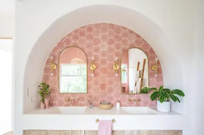 a bathroom with a pink tiled wall with a mirror at Casa Niri in Nicoya