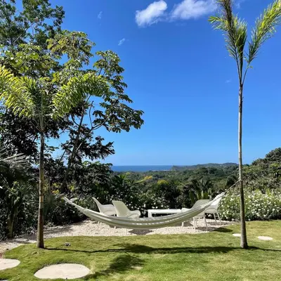 a hammock in a yard with two palm trees at Casa Niri in Nicoya