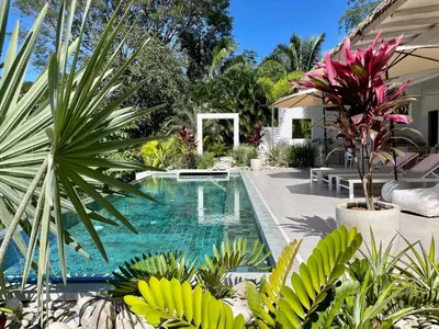 a swimming pool in a garden with plants at Casa Niri in Nicoya
