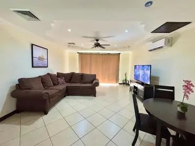 a living room with a brown couch and a table at Paradise Beach Apartment Herradura in Herradura