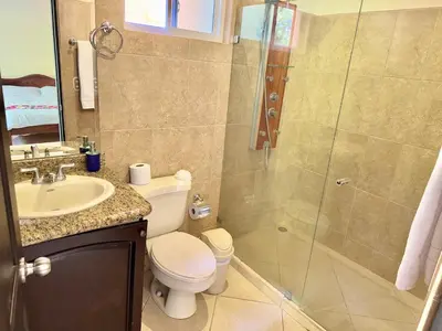 a bathroom with a shower and a toilet and a sink at Paradise Beach Apartment Herradura in Herradura