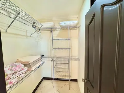 a walk in closet with a metal rack and towels at Paradise Beach Apartment Herradura in Herradura