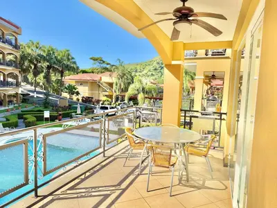 a balcony with a table and chairs and a view of the water at Paradise Beach Apartment Herradura in Herradura