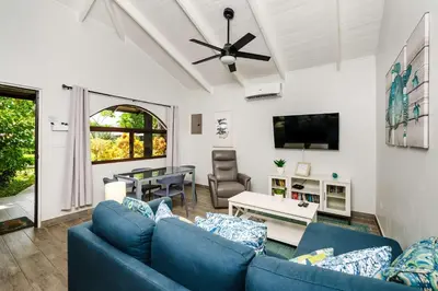a living room with a blue couch and a table at Private Patio Villa, Pool Access near Playa Penca in Potrero