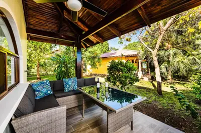 an outdoor patio with a couch and a table at Private Patio Villa, Pool Access near Playa Penca in Potrero