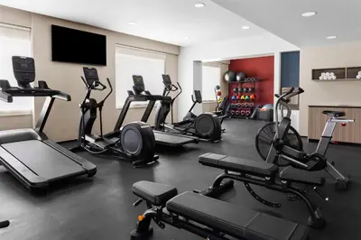 a gym with several exercise bikes and a flat screen tv at Homewood Suites By Hilton Cariari San Jose in San José