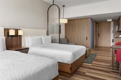 a hotel room with two beds and a desk at Homewood Suites By Hilton Cariari San Jose in San José