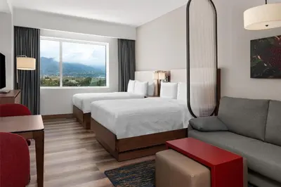 a hotel room with two beds and a couch at Homewood Suites By Hilton Cariari San Jose in San José