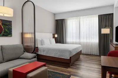 a hotel room with a bed and a couch at Homewood Suites By Hilton Cariari San Jose in San José