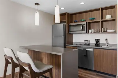 a kitchen with stainless steel appliances and wooden cabinets at Homewood Suites By Hilton Cariari San Jose in San José