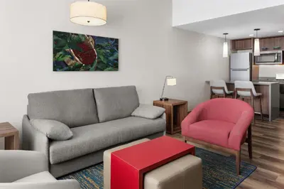 a living room with a couch and a red chair at Homewood Suites By Hilton Cariari San Jose in San José