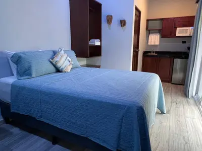 a bedroom with a bed with a blue comforter at Villa Binomio in Naranjito