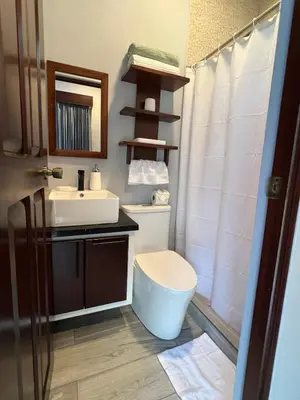 a bathroom with a sink and a toilet and a mirror at Villa Binomio in Naranjito