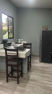 a kitchen with a table with chairs and a refrigerator at Bromelias in Tambor
