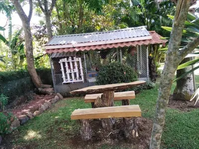 a wooden bench in front of a small house at Bromelias in Tambor