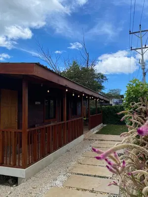 a building with a wooden fence and some flowers at Cabina Entre Playas in Huacas