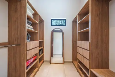 a walk in closet with wooden cabinets and a mirror at Stylish Private Tropical Escape-10 mins from Tamarindo in Villarreal