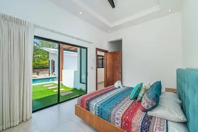 a bedroom with a bed and a large window at Stylish Private Tropical Escape-10 mins from Tamarindo in Villarreal
