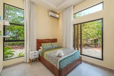 a bedroom with a bed with a stuffed animal on it at Stylish Private Tropical Escape-10 mins from Tamarindo in Villarreal