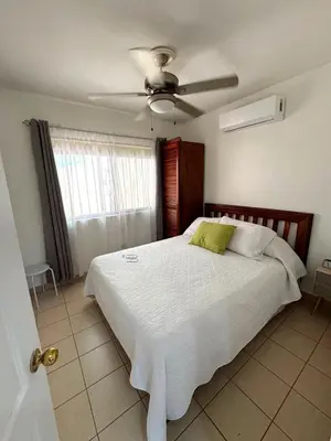 a bedroom with a bed with a ceiling fan at Casa Serena! in Coco