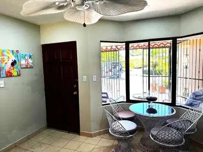 a living room with a ceiling fan and a table and chairs at Casa Serena! in Coco
