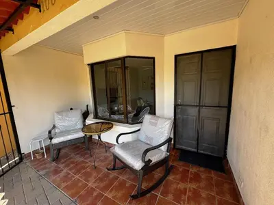 a balcony with two chairs and a table and a window at Casa Serena! in Coco