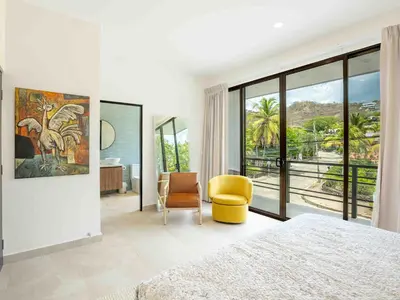 a bedroom with a king sized bed and a yellow chair at Mirame #4 - 3 Bedroom Villa Across from the Beach in Coco
