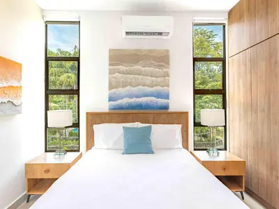 a bedroom with a bed with two night stands and two windows at Mirame #4 - 3 Bedroom Villa Across from the Beach in Coco