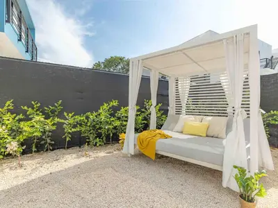 a white canopy bed with yellow pillows on a patio at Mirame #4 - 3 Bedroom Villa Across from the Beach in Coco