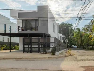 a white house with a balcony on a street at Mirame #4 - 3 Bedroom Villa Across from the Beach in Coco