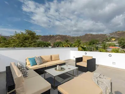a patio with couches and tables on a roof at Mirame #4 - 3 Bedroom Villa Across from the Beach in Coco