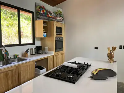 a kitchen with a stove and a white counter top at La Casa Mokarran in Ojochal