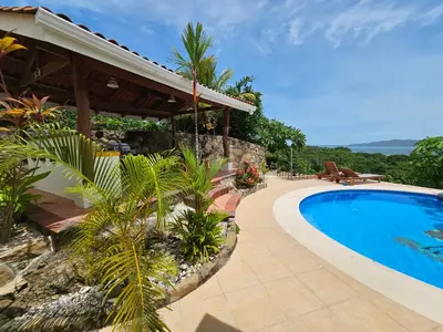 a resort with a swimming pool and a house at Roma del mar - Vila s bazénem a krásným výhledem na moře in Paquera