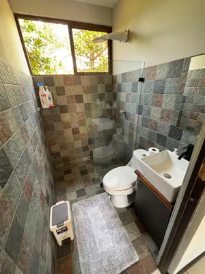 a bathroom with a toilet and a sink and a window at Casa de descanso in San Pablo