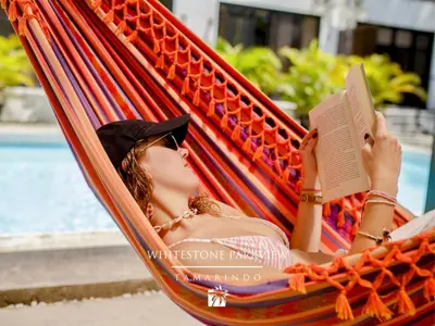 a woman laying in a hammock reading a book at Whitestone Parkview Tamarindo in Tamarindo